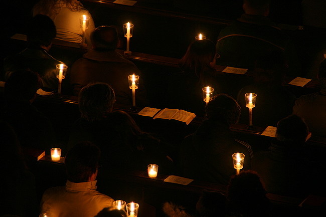 Kirchenbesucher und Kerzen als Lichtquelle